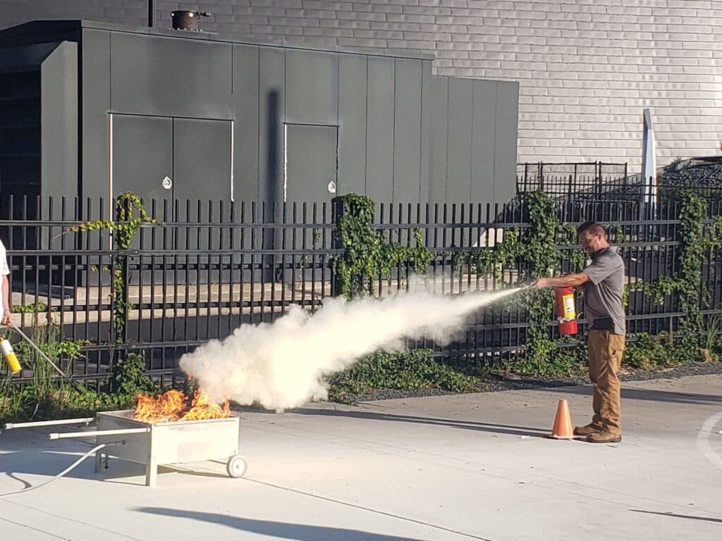 putting out a fire with a fire extinguisher as part of a demonstration next to the U.S. bank stadium