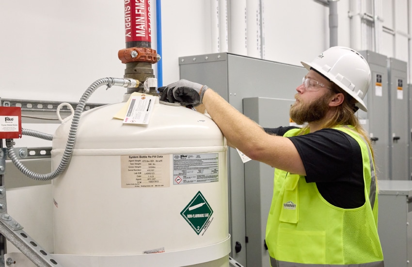Worker inspecting industrial fire safety equipment