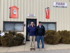 Two people standing outside of an office building
