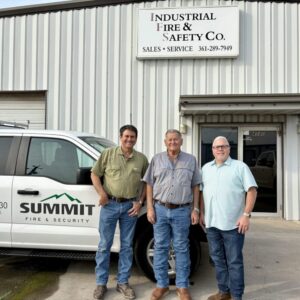 Three men in front of building.